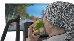 Obese senior person eating fatty sandwich during exercise on elliptical trainer