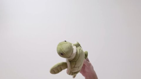 Child plays with a soft green turtle toy. Part_06. Child's hand with toy closeup.