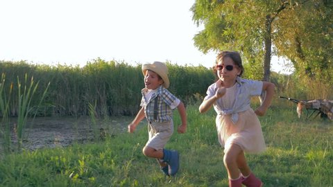 kids running around in the open air in the countryside during a happy weekend at sunset
