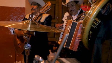 PATZCUARO, MEXICO - SEPTEMBER 15 2016 - Mexican mariachi musicians including a tuba, accordion, and guitar playing on the streets during Mexican Independence Day with audio