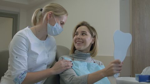 The dentist advises a satisfied client in the dentist's office
