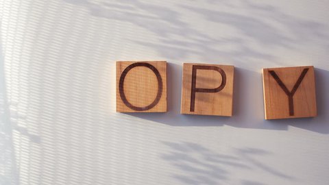 The word "COPY" is laid out in wooden letters