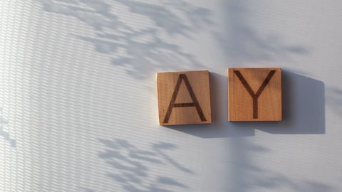 The word "DAY" is laid out in wooden letters