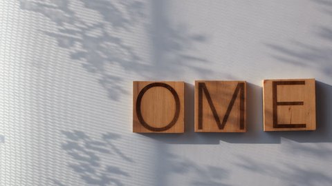 The word "HOME" is laid out in wooden letters