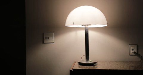 Person leaving apartment turning off lamp