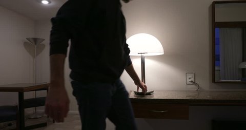 Man turning lights ON when arriving home