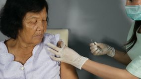 4k video of Doctor injecting flu vaccine to patient's arm in local hospital