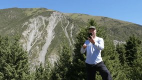 Tourist man using mobile phone for video call while mountain trip
