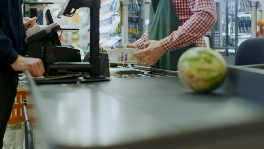 At the Supermarket: Checkout Counter Hands of the Cashier Scans Groceries, Fruits and other Healthy Food Items. Clean Modern Shopping Mall with Friendly Staff, Small Lines and Happy Customers. Royalty-Free Stock Footage #1015777333
