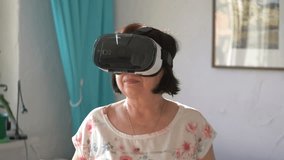 Senior woman exploring virtual reality in 4k slow motion 60fps
