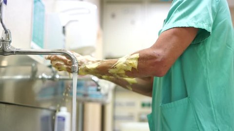 Hospital Worker Washing Hands With Iodine Before Procedure
