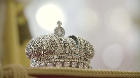 Gold and jewell-studded King's crown on a ceremonial pillow