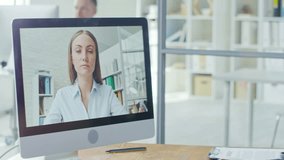 Tracking medium shot of concentrated black man discussing work with female colleague via video conversation