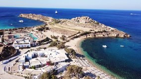 Aerial drone bird's eye view video from famous beach of Paraga featuring iconic club of Skorpios and Santanna the largest pool in Europe, Mykonos island, Cyclades, Greece