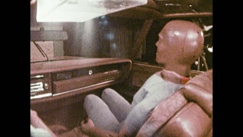 1980s: Backseat camera shows crash from inside car. Dummy slams into dashboard and windshield in slow motion. Dummy recoils violently into seat.
