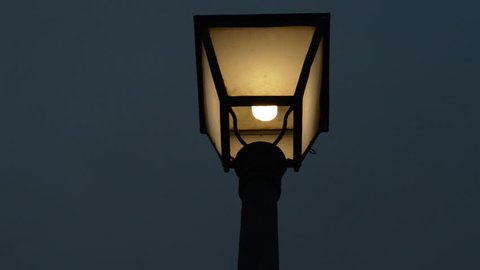 Lamppost turned on at night from the ground.