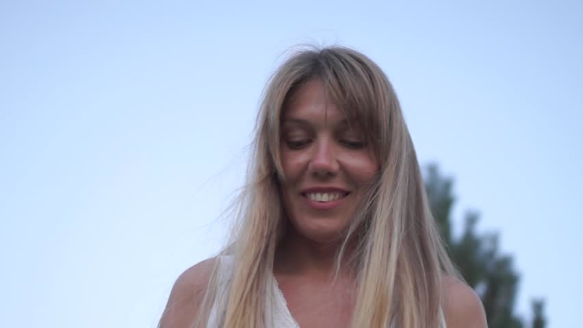 street portrait of a cute middle-aged girl in a white dress looks down