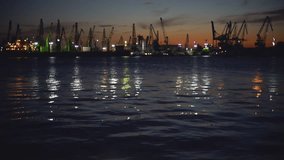 Sunset over industrial cranes and cargo ships in Varna port, Bulgaria