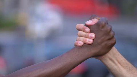 solidarity, equality, brotherhood.hands of a white man and a black man greeting