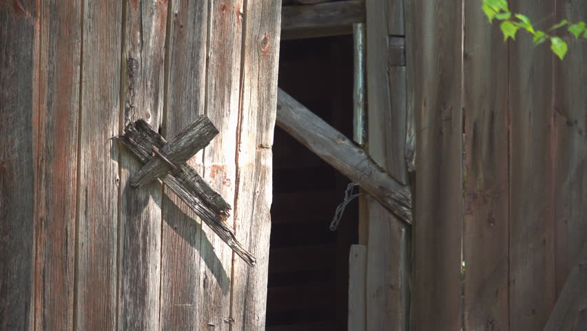 Wooden door latch in the shape of a broken christian cross