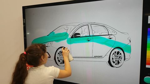 A girl paints LADA car on an interactive whiteboard at Moscow Automobile Salon. SEP 03, 2018 MOSCOW, RUSSIA
