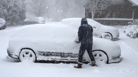 Man Shoveling Snow off Car