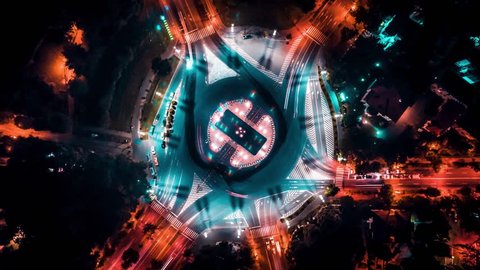 Aerial drone time lapse of a busy intersection at night moving traffic above city arch triumph Bucharest