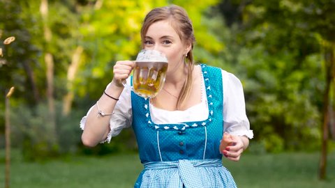 Young woman in blue bavarian costume celebrating oktoberfest