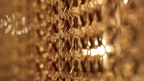 Slow, smooth movement of long gold chains. Uniform swing. Gold background for relaxation. Meditation. Relax. Texture for soothing. Glitter. Vertical picture. Blurred Stock Video