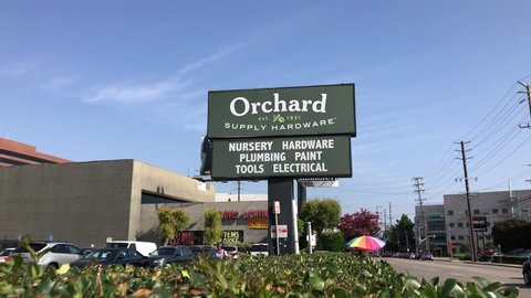LOS ANGELES, Sep 1, 2018: Close up of an OSH Orchard Supply Hardware store sign and logo next to a West LA store against a blue sky with plants in foreground. The chain is set to close in October.