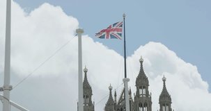 The Union Jack flying from Parliament behind flag poles
