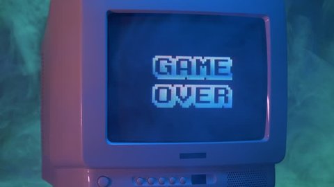 GAME OVER title on a tube TV Vintage 80's 90's arcade.Zooming out with fog giving a retro look at the scene.