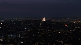 Aerial video of the Sacre Coeur Basilica at night in Paris France with a zoom lens.