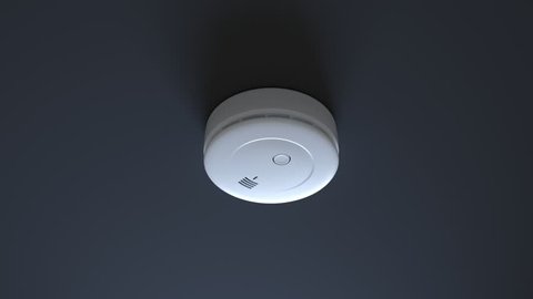 Dense smoke gathering around and surrounding a smoke detector on a white ceiling. Alarm activates, red and yellow lights are blinking suDense smoke gathering around and surrounding a smoke detector on