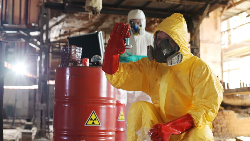 Young Caucasian man in hazmat outfit, holding in hand strange thing. Slavic guy in gas mask. Squatting position. Important experiment. Danger. Royalty-Free Stock Footage #1015910944