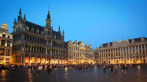 BRUSSELS, BELGIUM - MAY 31, 2018: Grote Markt (Grand Place) square crowded with tourists illuminated at night. Bruxelles, Belgium. With horizontal camera panning