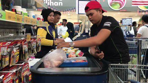 Subang Jaya, Selangor, Malaysia - September 2nd, 2018; A customer put various goods on counter cashdesk in supermarket. Selective focus and handheld camera.