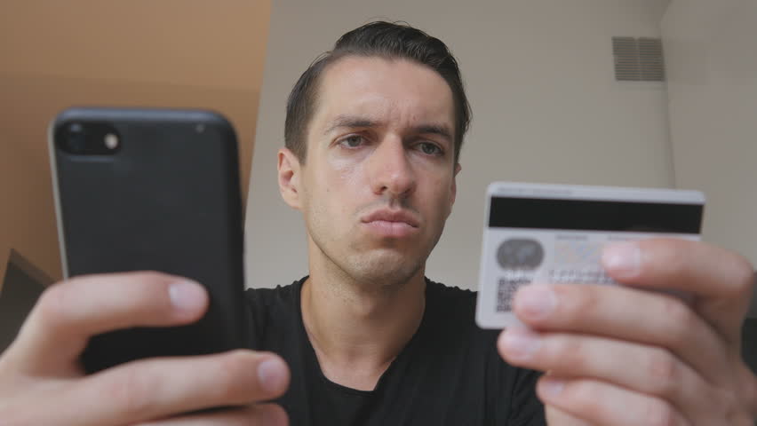Angry young man buying online uses a phone and a credit card and feeling that he was deceived. Unsuccessful Internet shopping. Credit card fraud Royalty-Free Stock Footage #1015913647