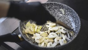 Frying potato with mushroom and onion in butter oil using a frying pan in restaurant kitchen