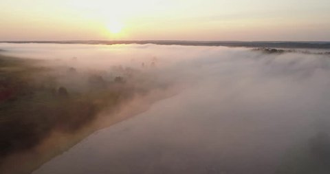 orange sunrise on the river, 4K aerial view of morning mist at sunrise, orange rays of the sun through the morning mist on the river,  Aerial view of mystical river at sunrise with fog
 Video stock