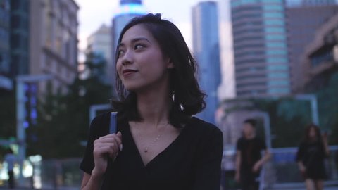 One pretty young asian girl walking in the city street with black dress in slow motion