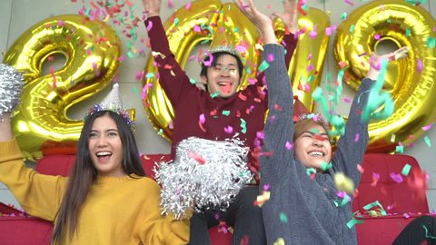 Group of friends enjoy party happy New Year golden balloon 2019 and throwing confetti.