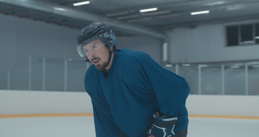 Caucasian male ice hockey player catching breath during practice at the training arena. 4K UHD | Shutterstock HD Video #1015928176
