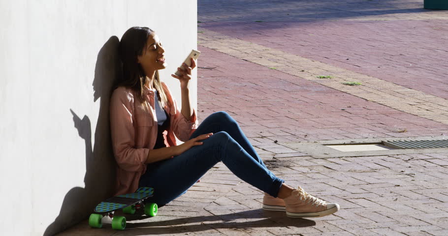 Beautiful woman talking on mobile phone during sunny day 4k