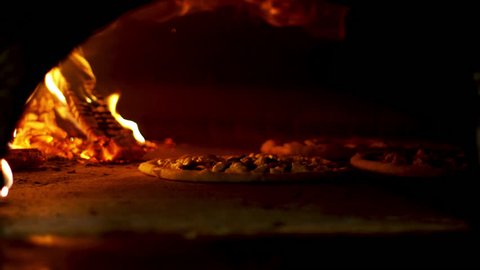 Italian Pizza cooking in the oven with wood fire