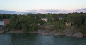 4K summer sunset aerial video of Helsinki Lapinlahti historical mental hospital completed in 1841, not in operation from 2008, woods area around it, in the capital of Finland Suomi, northern Europe