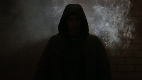 The hooded man in the smoky room near brick wall HD - Powered by Shutterstock - Get 15% off with code: PIKWIZARD15
