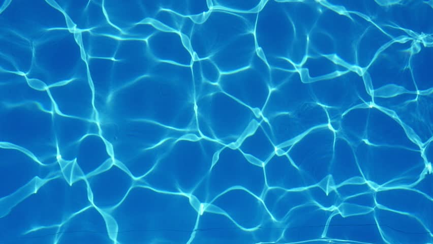 Up down view of swaying light blue waters in a spacious and luxury looking swimming pool with sparkling lines forming a nice background.  Royalty-Free Stock Footage #1015960642