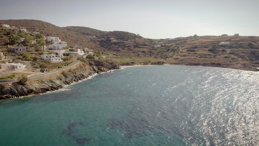 Aerial view of large white villas in front of beach at Ydroussa, Andros island.