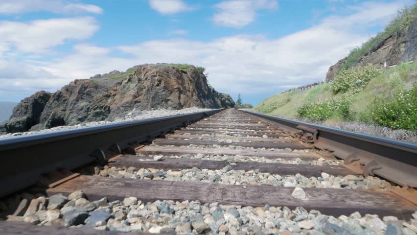 Track along Alaska Railroad tracks with mountains and rocky scenery.